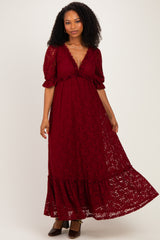 woman wearing a burgundy lace maxi dress with puff sleeves and a ruffled hem