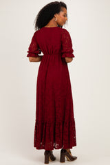 woman wearing a burgundy lace maxi dress with ruffled sleeves and a tiered hem, viewed from the back