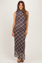 woman wearing a black and white plaid maternity maxi dress with a high neckline and a form-fitting silhouette, showcasing her baby bump