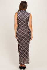 woman wearing a brown plaid maternity maxi dress with a high slit, showing a pregnant baby bump from the back