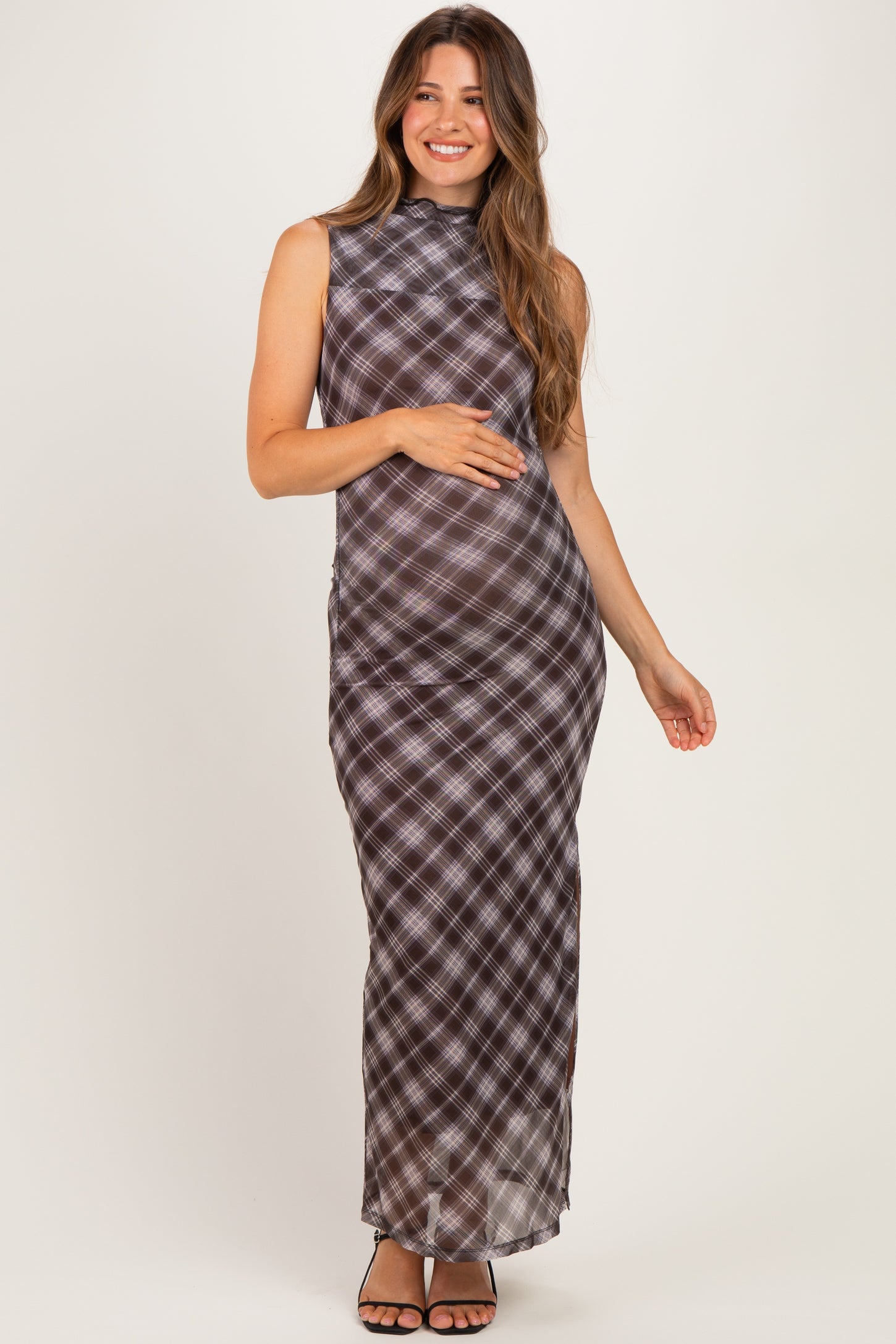 woman wearing a brown and black plaid maternity maxi dress with a high neckline and a visible baby bump