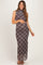 woman wearing a brown and black plaid maternity maxi dress with a high neckline and a visible baby bump