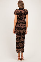 woman wearing a brown floral lace maternity dress with a fitted silhouette and short sleeves, showing a baby bump