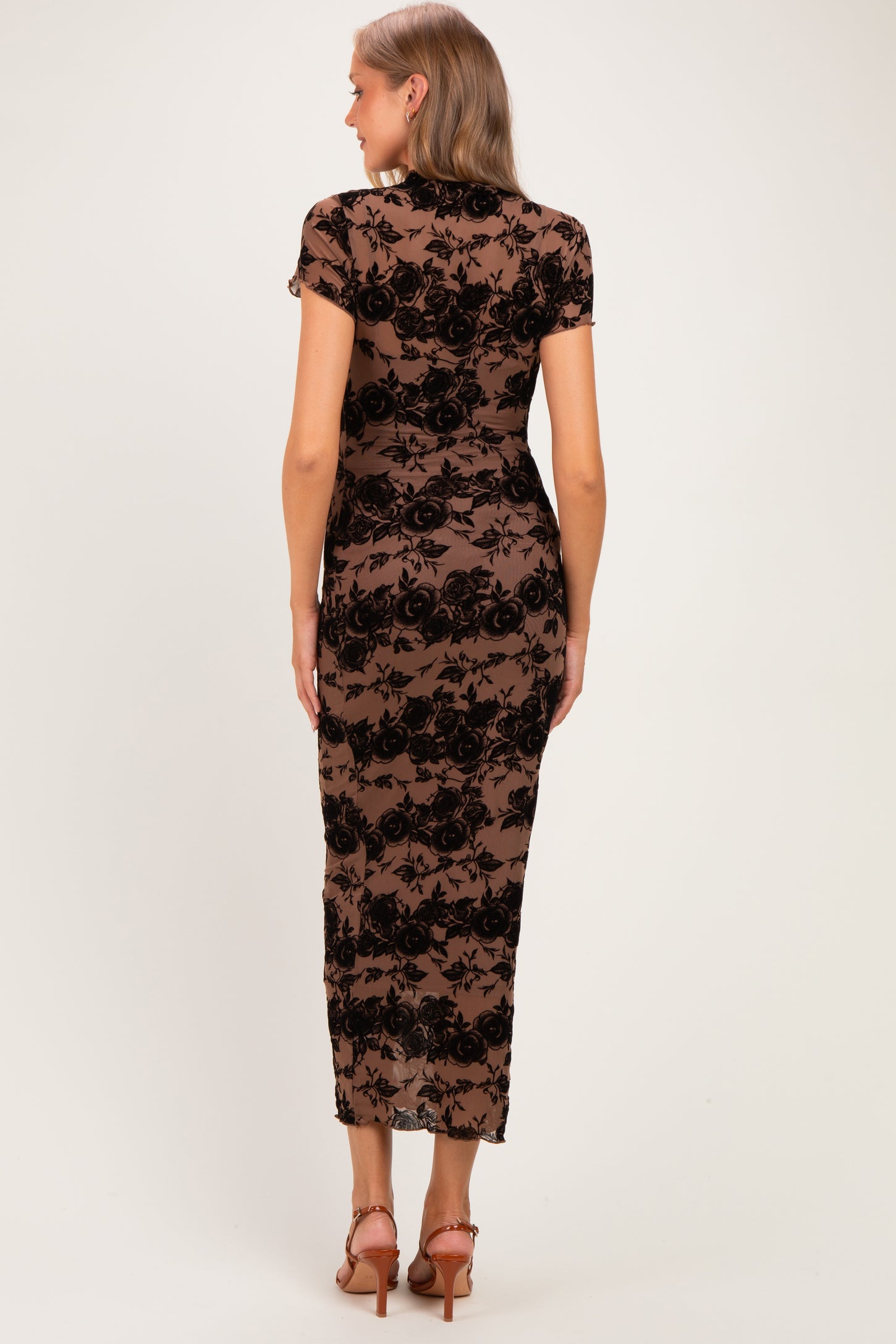 woman wearing a black lace maternity dress with short sleeves and a fitted silhouette, showing a smooth silhouette from the back