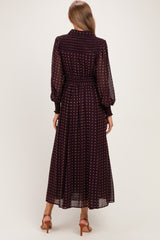 woman wearing a burgundy long sleeve maternity dress with white polka dots, showing the back view and a flowing skirt
