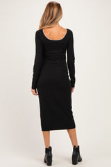 woman wearing a black long sleeve maternity dress, fitted style, showing the back view