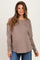 woman wearing a taupe long sleeve maternity top with a relaxed fit and side ruching