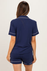woman wearing a navy blue maternity pajama set with a short sleeve top and shorts