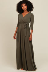 woman wearing an olive green long sleeve wrap dress with a tie waist and flowing skirt