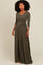 woman wearing an olive green long sleeve wrap dress with a tie waist and flowing skirt