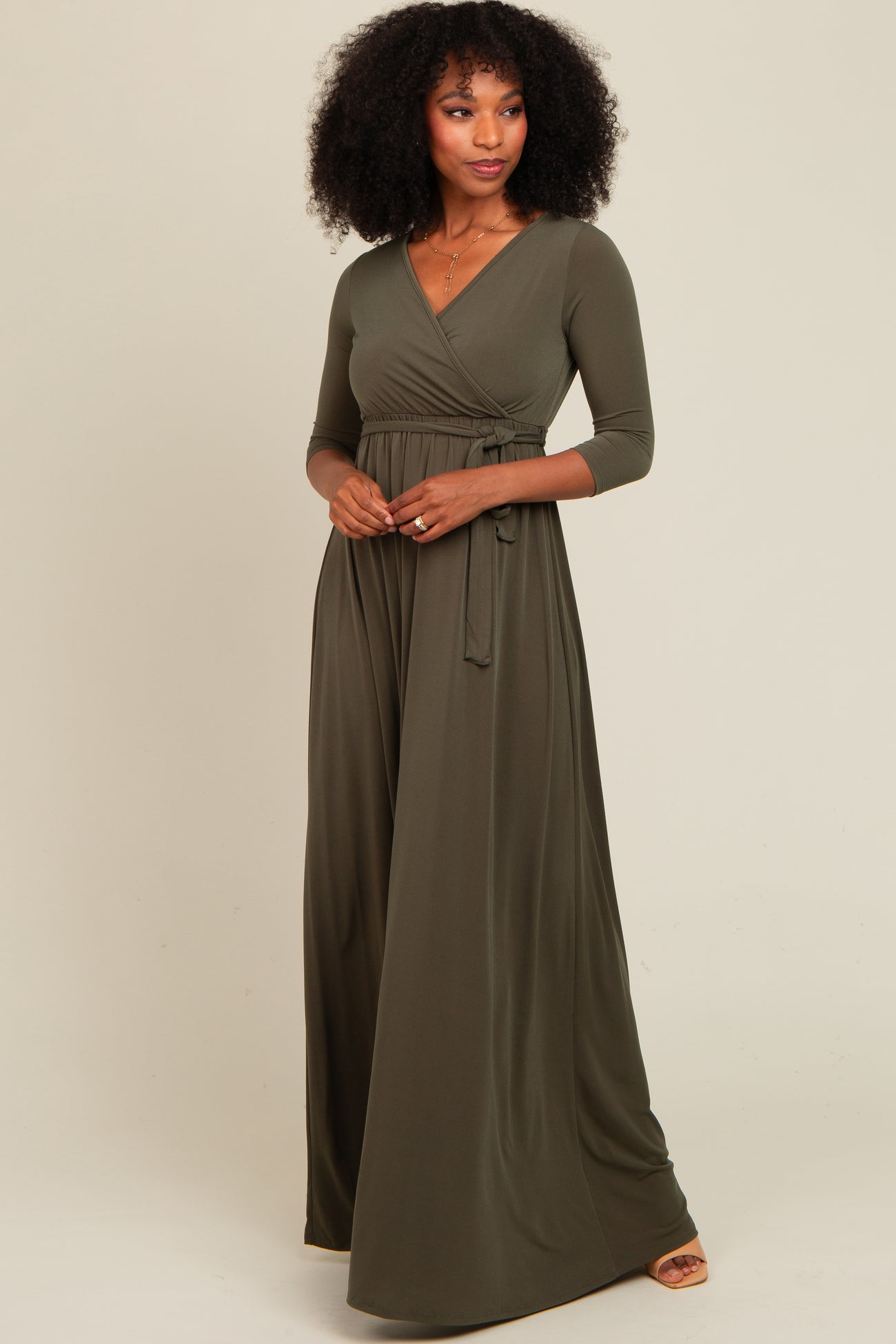 woman wearing an olive green long sleeve wrap maxi dress with a tied waist detail