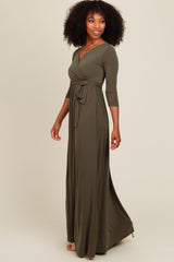 woman wearing a long olive green wrap dress with three-quarter sleeves and a tied waist