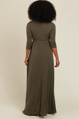 woman wearing a long olive green maxi dress with three-quarter sleeves and a cinched waist, viewed from the back
