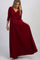 woman wearing a burgundy maternity maxi dress with a wrap design and three-quarter sleeves, showing a baby bump