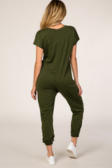 woman wearing a green maternity jumpsuit with short sleeves and tapered pants, showing a relaxed fit from the back
