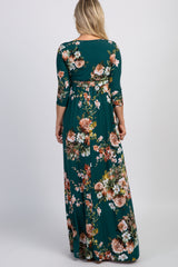 woman wearing a floral print green maternity maxi dress with three-quarter sleeves, showing the back view