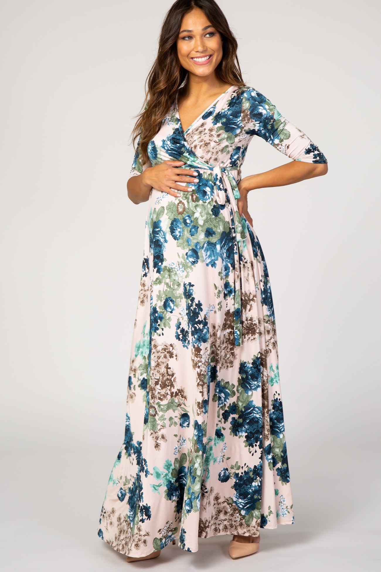 woman wearing a floral wrap maternity dress with three-quarter sleeves and a visible baby bump