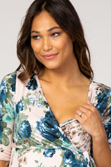 woman wearing a floral print maternity dress with a wrap design and a visible baby bump
