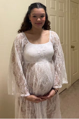 woman wearing a white lace maternity gown and holding her baby bump