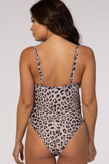woman wearing a leopard print maternity swimsuit seen from the back, showcasing adjustable straps and a high-cut leg design