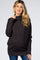 woman wearing a dark gray maternity turtleneck sweater and showing her baby bump while smiling