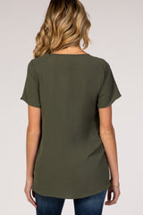 woman wearing a dark green short sleeve maternity top, viewed from the back