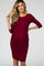 Pregnant woman wearing a burgundy three-quarter sleeve pleated maternity dress against a grey background