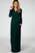 pregnant woman wearing a long sleeve forest green maternity maxi dress with a v-neckline and pockets