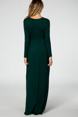 woman wearing a dark green long sleeve maternity maxi dress, seen from the back