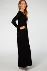 woman wearing a flattering black long sleeve maxi dress with a fitted bodice and flowing skirt