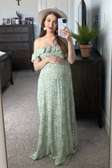 pregnant woman in green floral off-the-shoulder maternity maxi dress taking a mirror selfie
