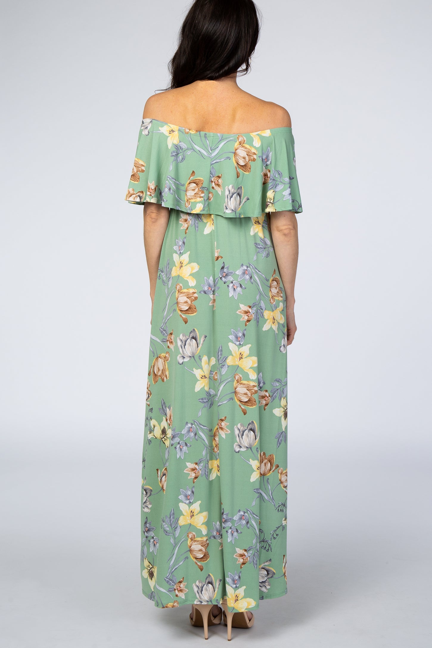 woman wearing a light green floral off-the-shoulder maxi dress, showing the back view
