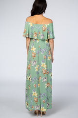 woman wearing a light green floral off-the-shoulder maxi dress, showing the back view