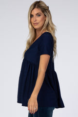 woman wearing a navy blue short sleeve peplum top with textured fabric and a relaxed fit