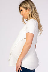 woman wearing a white short sleeve maternity top and showing her baby bump
