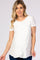 woman wearing a white short sleeve maternity top with a wrap design and a relaxed fit