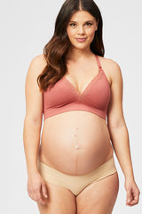 woman wearing a dusty rose maternity bra with lace detail and showing her baby bump