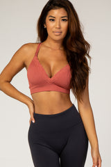 woman wearing a rust colored lace trim bralette paired with high-waisted black leggings