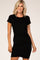 blonde woman wearing a short sleeve black ruched bodycon mini dress