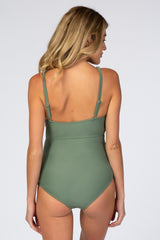 Back view of a woman wearing a sage green one-piece swimsuit with adjustable spaghetti straps