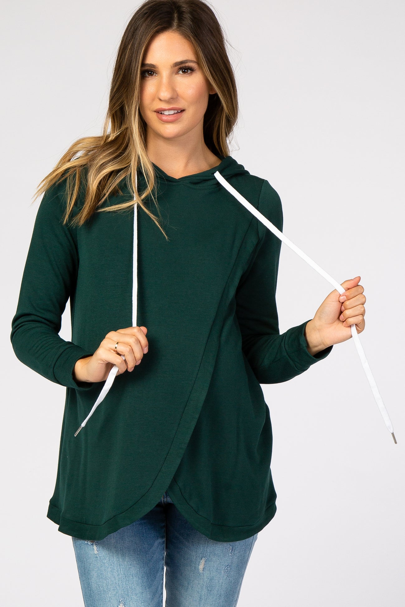 woman wearing a dark green maternity hoodie with a white drawstring and relaxed fit