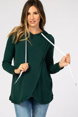 woman wearing a dark green maternity hoodie with a white drawstring and relaxed fit