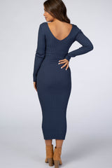 woman wearing a navy ribbed long sleeve maternity dress with a v-back, showing her baby bump