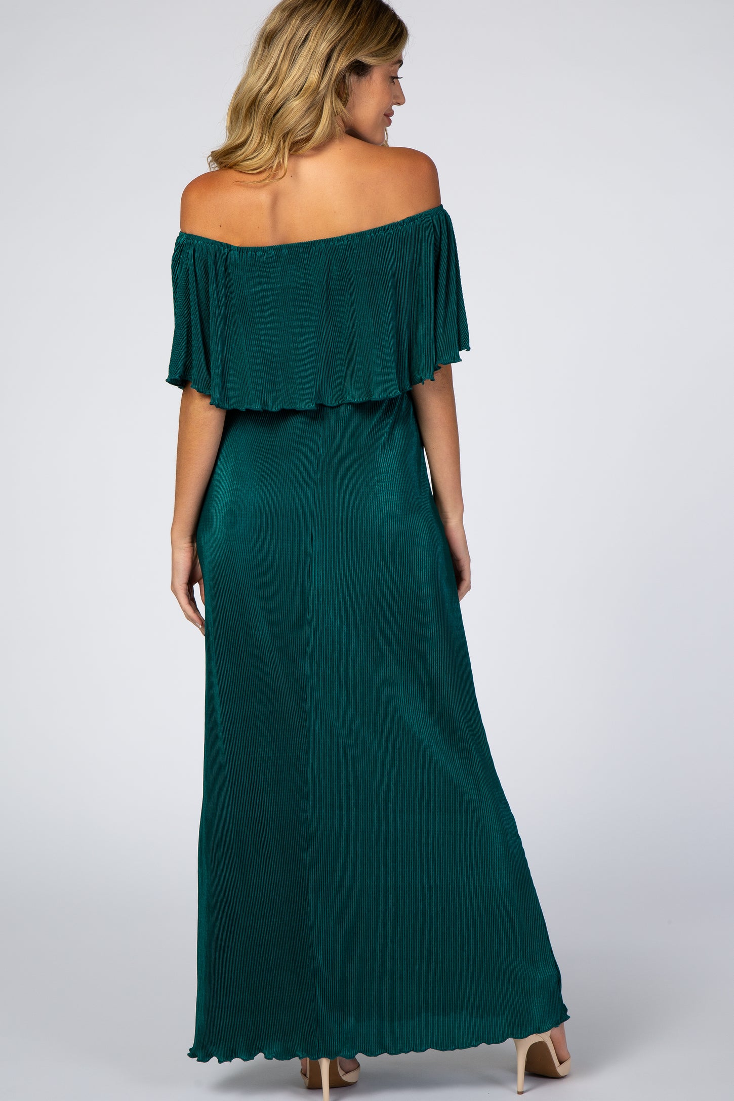 woman wearing a teal off-the-shoulder maxi maternity dress with a layered ruffle detail in the back