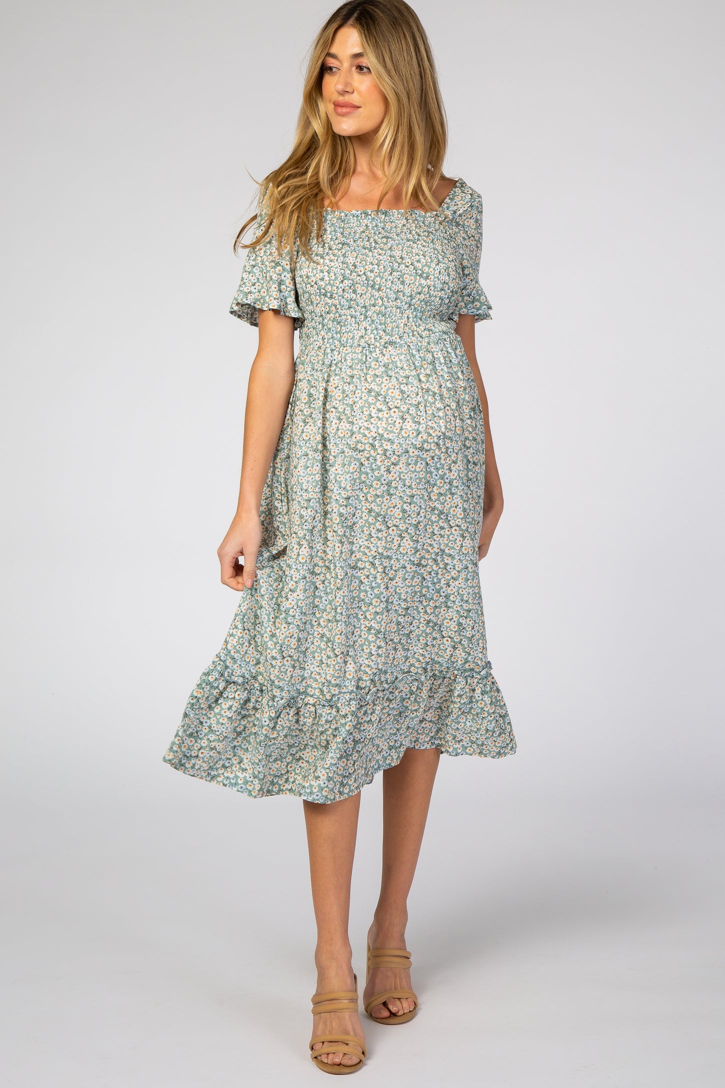 woman wearing a light blue floral print maternity dress with short sleeves and a tiered skirt, baby bump visible