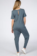 woman wearing a slate blue maternity jumpsuit with short sleeves and a back keyhole detail