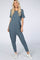 woman wearing a casual teal short sleeve jumpsuit with a relaxed fit and white sneakers