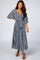 woman wearing a navy blue and white patterned maxi dress with a cinched waist and wide sleeves