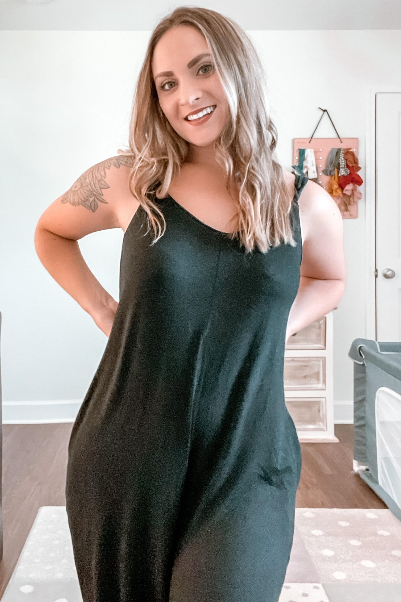 woman wearing a black sleeveless maxi dress with a relaxed fit and side pockets