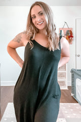 woman wearing a black sleeveless maxi dress with a relaxed fit and side pockets